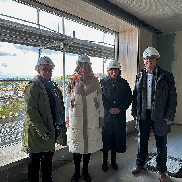 Besucher auf der Baustelle tragen Schutzhelme